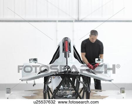 Engineer inspecting carbon fibre car body shell in sports car factory View Large Photo Image Stock Image - Engineer inspecting carbon fibre car body shell in sports car factory. Fotosearch