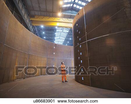 Stock Image - Engineer inspecting marine fabrication used for cable laying. Fotosearch