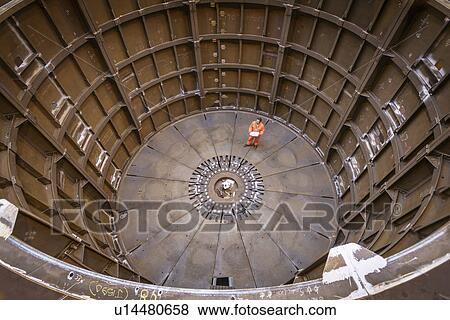 Stock Photo - Engineer inspecting marine fabrication used for cable laying, high angle view. Fotosearch