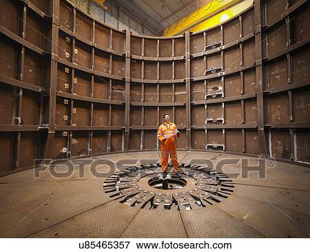 Stock Photo - Engineer inspecting marine fabrication used for cable laying. Fotosearch