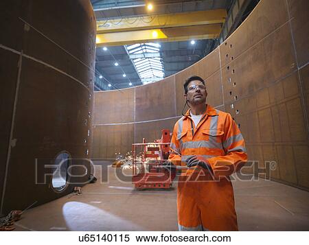 Stock Photography - Engineer inspecting marine fabrication used for cable laying. Fotosearch