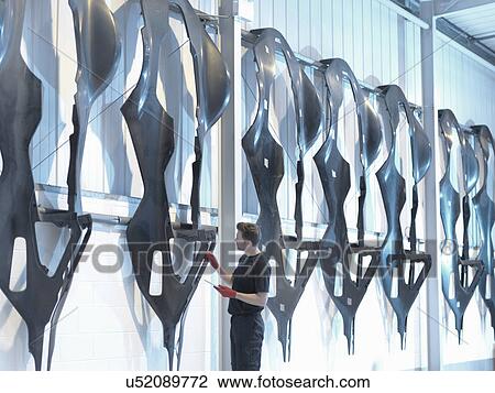 Engineer inspects carbon fibre car body shells in racing car factory View Large Photo Image Stock Image - Engineer inspects carbon fibre car body shells in racing car factory. Fotosearch