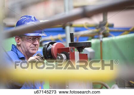 Stock Image - Engineer operating boring machine during power station outage. Fotosearch
