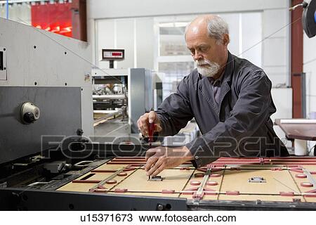 Engineer repairing manufacturing machine in cardboard factory View Large Photo Image Stock Image - Engineer repairing manufacturing machine in cardboard factory. Fotosearch