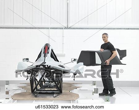 Engineer with part assembled supercar in car factory View Large Photo Image Stock Image - Engineer with part assembled supercar in car factory. Fotosearch
