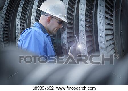 Engineer with torch inspecting turbine during power station outage View Large Photo Image Stock Image - Engineer with torch inspecting turbine during power station outage. Fotosearch