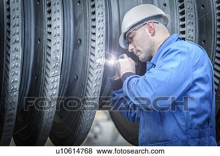 Engineer with torch inspecting turbine during power station outage View Large Photo Image Stock Photo - Engineer with torch inspecting turbine during power station outage. Fotosearch
