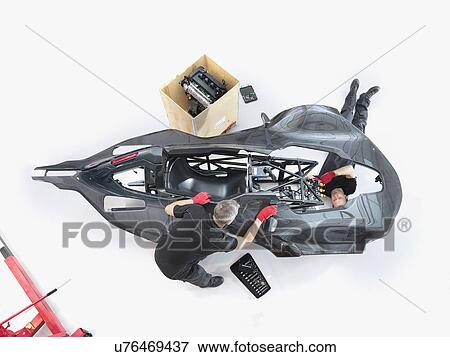 Engineers assembling supercar in sports car factory, overhead view View Large Photo Image Stock Photo - Engineers assembling supercar in sports car factory, overhead view. Fotosearch