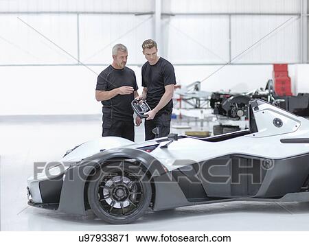 Engineers discussing supercar in sports car factory View Large Photo Image Stock Image - Engineers discussing supercar in sports car factory. Fotosearch