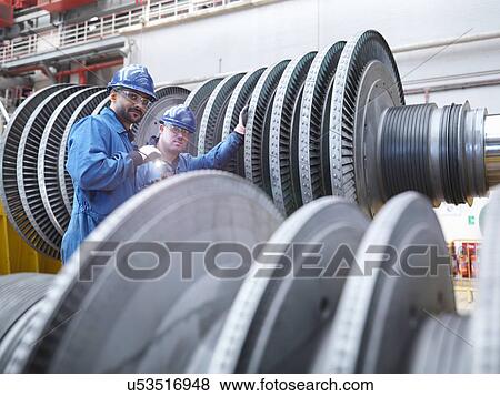 Stock Photo -  Engineers inspecting turbine during power station outage, portrait. Fotosearch