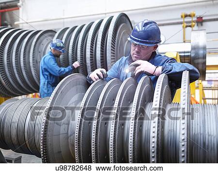 Stock Photo -  Engineers inspecting turbine during power station outage, portrait. Fotosearch