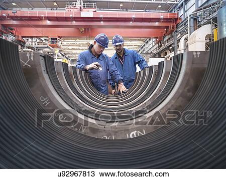 Stock Image - Engineers inspecting turbine housing during power station outage. Fotosearch