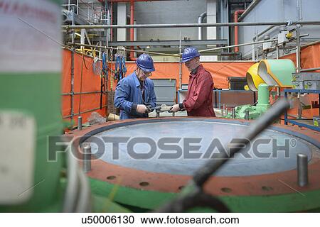 Stock Image - Engineers repairing flange valves during power station outage. Fotosearch