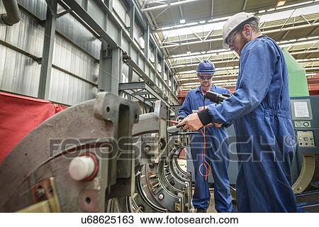 Stock Image - Engineers working on turbine housing repair during power station outage. Fotosearch