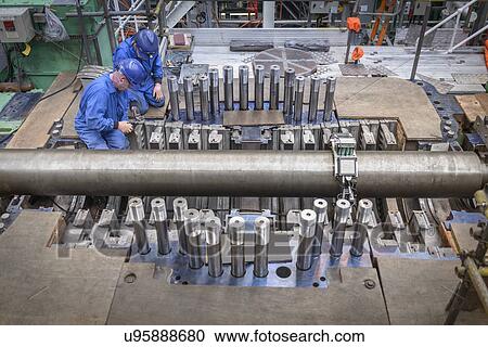 Stock Image - Engineers working on turbine housing repair during power station outage, high angle view. Fotosearch
