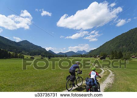Father and son cycling through Jachenau, Bavaria, Germany View Large Photo Image Stock Image - Father and son cycling through Jachenau, Bavaria, Germany. Fotosearch