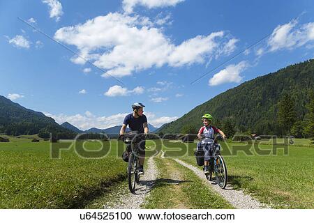 Father and son cycling through Jachenau, Bavaria, Germany View Large Photo Image Stock Image - Father and son cycling through Jachenau, Bavaria, Germany. Fotosearch