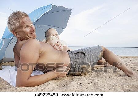 Father with son and daughter relaxing on beach View Large Photo Image Stock Photo - Father with son and daughter relaxing on beach. Fotosearch