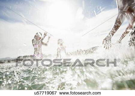 Father with son and daughter splashing each other on beach View Large Photo Image Stock Photo - Father with son and daughter splashing each other on beach. Fotosearch