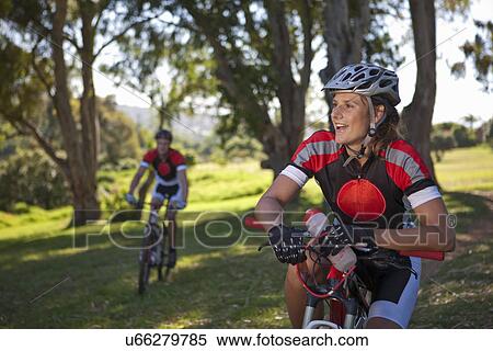 Stock Photography - Female cyclist on bicycle taking break. Fotosearch