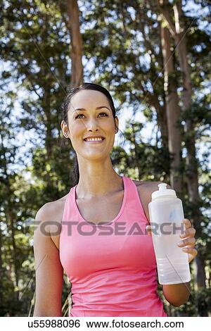 Stock Photograph - Female jogger holding water bottle. Fotosearch
