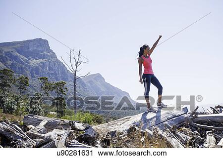 Female jogger in winning pose on hilltop View Large Photo Image Stock Image - Female jogger in winning pose on hilltop. Fotosearch