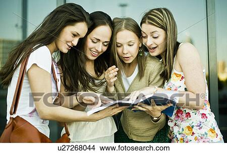 Four young female friends looking and laughing at notebook View Large Photo Image Picture - Four young female friends looking and laughing at notebook. Fotosearch