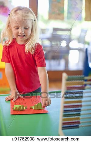Stock Photo - Girl counting with fingers at nursery school. Fotosearch