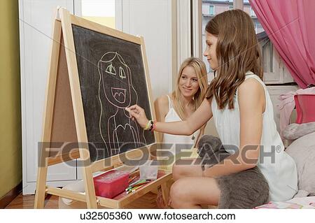 Girl drawing portrait of her mother on blackboard View Large Photo Image Stock Image - Girl drawing portrait of her mother on blackboard. Fotosearch