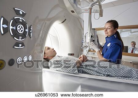 Stock Image - Girl going into CT scanner. Fotosearch