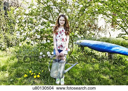 Picture - Girl holding watering can, portrait. Fotosearch