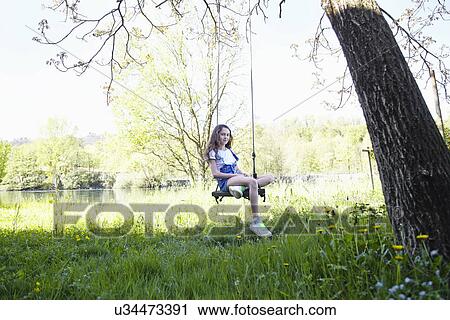 Girl on swing in tree, portrait View Large Photo Image Stock Image - Girl on swing in tree, portrait. Fotosearch