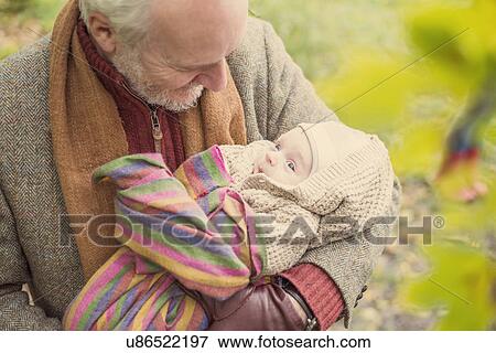 Grandfather cradling grandson, high angle View Large Photo Image Stock Photo - Grandfather cradling grandson, high angle. Fotosearch