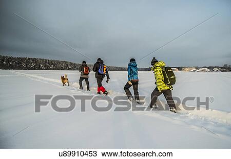 Group of friends and dog walking on snow View Large Photo Image Stock Image - Group of friends and dog walking on snow. Fotosearch