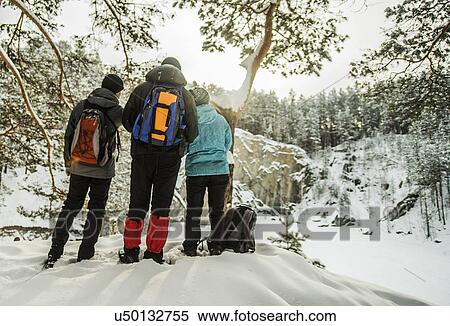 Stock Photography - Group of friends enjoying view of snow covered forest, Russia. Fotosearch