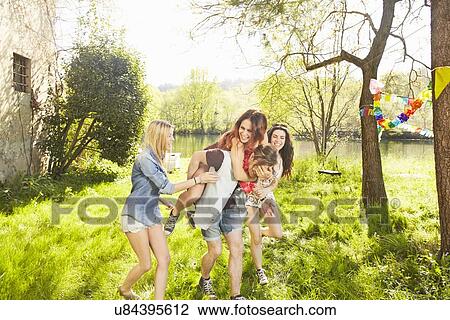 Group of friends, man giving woman piggy back View Large Photo Image Stock Image - Group of friends, man giving woman piggy back. Fotosearch