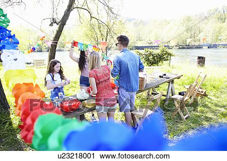 Group of friends setting up picnic View Large Photo Image Stock Image - Group of friends setting up picnic. Fotosearch