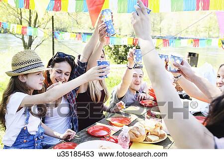 Group of friends toasting at a picnic View Large Photo Image Stock Image - Group of friends toasting at a picnic. Fotosearch