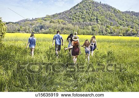 Group of friends walking in field View Large Photo Image Stock Photo - Group of friends walking in field. Fotosearch