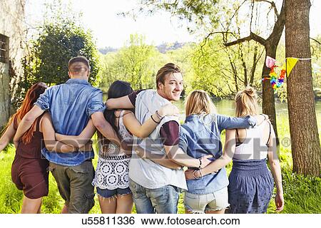 Stock Photograph - Group of friends with arms around each other. Fotosearch