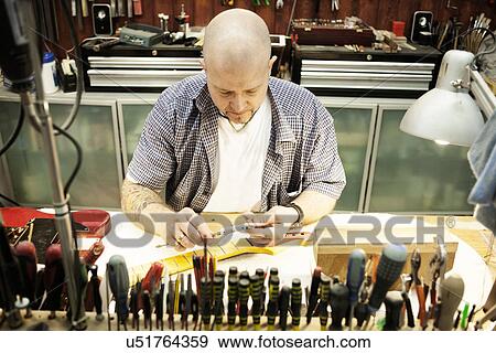 Guitar maker measuring guitar neck in workshop View Large Photo Image Stock Photo - Guitar maker measuring guitar neck in workshop. Fotosearch