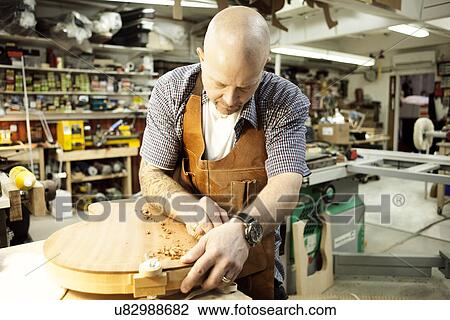 Guitar maker measuring wooden guitar shape in workshop View Large Photo Image Stock Image - Guitar maker measuring wooden guitar shape in workshop. Fotosearch