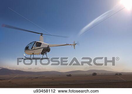 Stock Image - Helicopter flying close to ground. Fotosearch