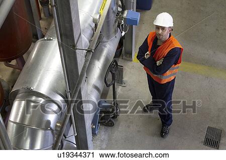 Stock Image - High angle portrait of male technician in power station. Fotosearch