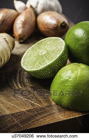 Stock Photograph - Ingredients for making green curry paste - lime, garlic, onion, ginger. Fotosearch