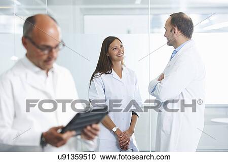Male doctor using digital tablet, colleagues in background View Large Photo Image Stock Image - Male doctor using digital tablet, colleagues in background. Fotosearch