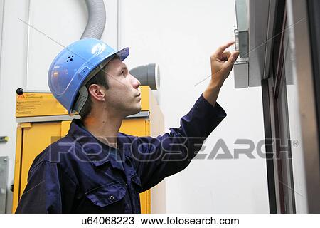 Male electrician checking power control panel in factory View Large Photo Image Stock Image - Male electrician checking power control panel in factory. Fotosearch