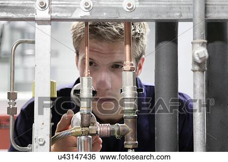 Male engineer maintaining industrial supply pipes in factory View Large Photo Image Stock Photograph - Male engineer maintaining industrial supply pipes in factory. Fotosearch