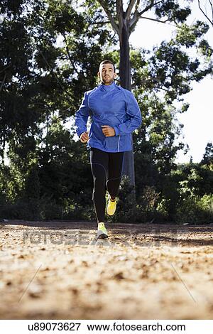 Stock Photo - Male jogger in forest. Fotosearch