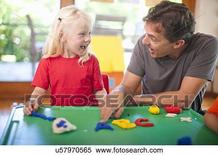 Stock Photography - Male teacher and girl learning alphabet at nursery school. Fotosearch